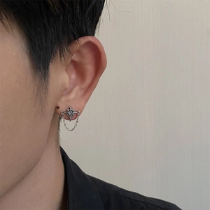 Close-up of silver star stud earring with a dangling chain and minimalist U-shaped design