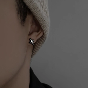 Cross stud earring with black crystals in silver setting on male model with beanie