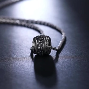 Macro shot of an antique finish cylindrical pendant with intricate relief carvings