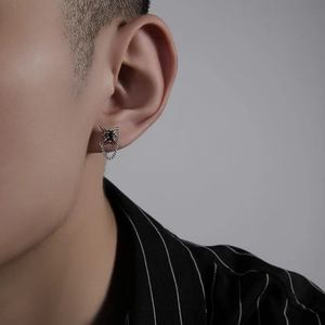 Detail of silver stud earring with black stone and chain tassel on male model