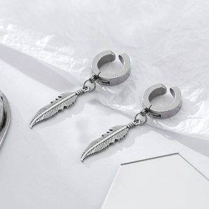 Détail des breloques plumes rétro sur des boucles d'oreilles clips en acier argent