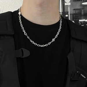 Collier géométrique argenté avec pendentifs losanges porté par un homme style urbain