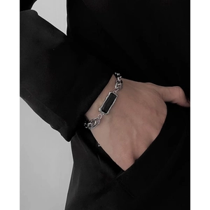 Détail d'un bracelet gourmette argenté de style hip-hop avec onyx noir rectangulaire