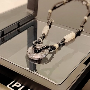 Collana di perle retrò con ciondolo a ciambella in pietra grigia e perline nere su specchio