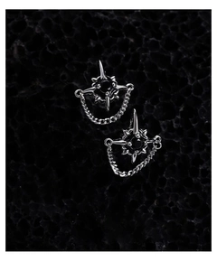 Detail of gothic star ear studs with black gemstones and hanging metal chains