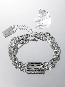 Détail d'un bracelet multicouche argenté avec pierre noire rectangulaire sur miroir
