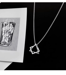 Macro view of geometric interlaced square pendant with sleek stainless steel chain link