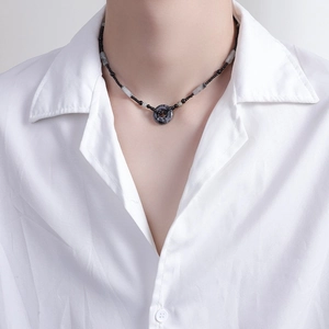 Dettaglio della collana di perline con ciondolo ad anello marmorizzato su camicia