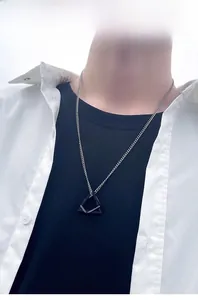 Hip hop style pendant with black and silver square frames on a thin metal chain