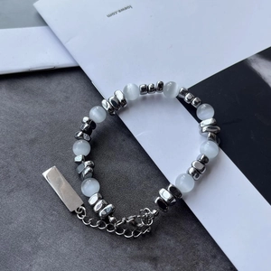 Gros plan du bracelet en œil de chat et perles argentées avec fermoir mousqueton