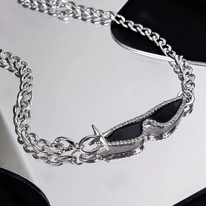 Detail of silver tank chain necklace featuring a star charm and black crystal pendant