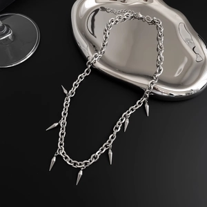 Detailaufnahme der Punk-Halskette mit Metall-Spikes auf silbernem flüssigem Tablett