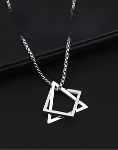 Macro view of men's silver geometric double triangle pendant on a box chain
