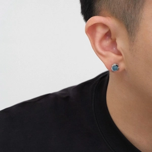 Nahaufnahme von minimalistischem blauem Topas-Ohrstecker mit Silberbasis am Model