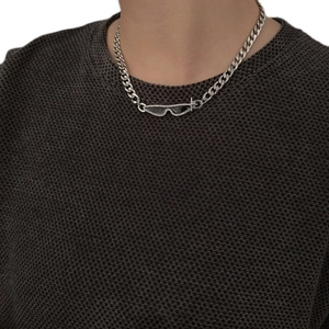 Detail of silver link chain necklace with black sunglasses pendant on grey sweater
