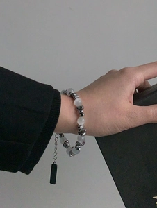 Vue détaillée des perles œil de chat et perles en métal argenté sur bracelet en acier