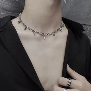Detail der silbernen Spike-Halskette mit Metallanhängern am Modell im Punk-Stil
