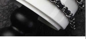 Détail macro de la chaîne en acier titane argenté tressée de cuir noir pour bracelets chic