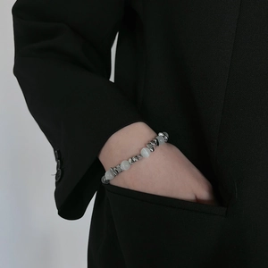 Bracelet élégant en œil de chat et perles d'acier titane sur modèle en costume noir