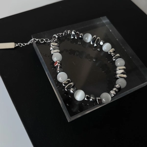 Bracelet moderne en perles d'opale et acier titane sur support en acrylique haut de gamme