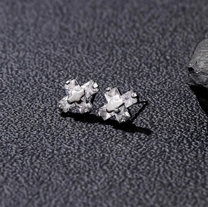 Gros plan de boucles d'oreilles croix en argent serties de zircons rectangulaires griffés