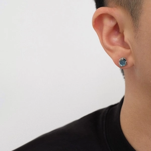 Unisex Medusa-Ohrstecker aus Silber mit blauem Topas-Stein, getragen von einem Model