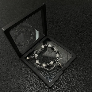 Detail view of gothic beaded bracelet with ice crack beads and silver cross pendant