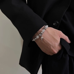 Detail of beaded double layer bracelet with star pendant on male wrist in black suit
