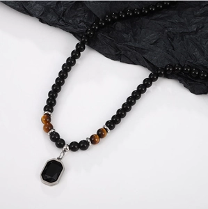 Macro detail of obsidian beaded necklace with tiger eye accents and faceted black pendant