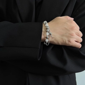 Detail of layered titanium steel bracelet with ice-crack beads and star charms on wrist
