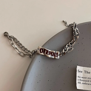 Macro d'un bracelet double chaîne en titane argenté avec plaque métallique rouge OFBOA