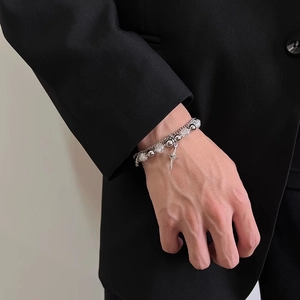 Detail of a double-layer silver bracelet featuring star pendant and crystal beads on wrist
