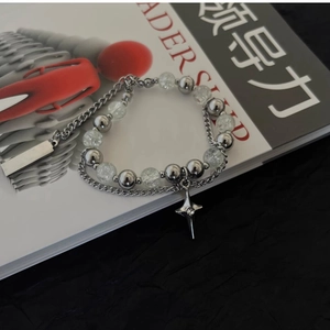 Close-up of double-layered beaded bracelet with crackle beads and star pendant
