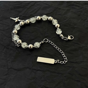Detailed macro of double-layer bracelet with ice crack beads and steel cross pendant