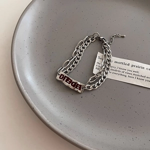 Vue détaillée du bracelet double chaîne en titane argenté avec gravure Dream rouge