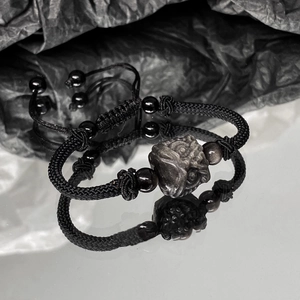 Men's black woven bracelet with carved guardian lion stone and mirror reflection