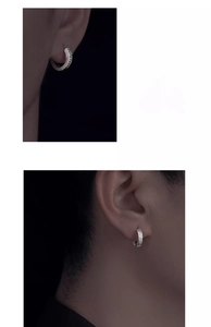 Close-up of men's silver titanium steel hoop earrings with Greek key pattern on ear