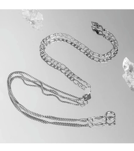Macro detail of silver layered Figaro and box chains with reflective mirror finish