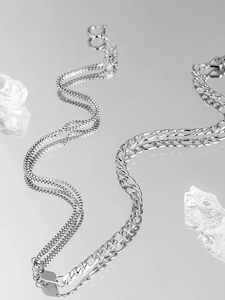 Detail shot of Figaro and box chain necklaces with polished silver metallic finish