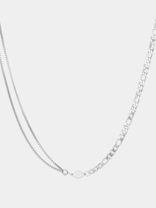Detail of silver asymmetrical necklace featuring layered box chains and Figaro links