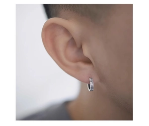 Close-up of titanium steel huggie earring with Greek Key pattern worn on ear