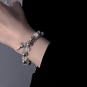 Double-layered stainless steel bracelet with silver beads and cross pendant on wrist