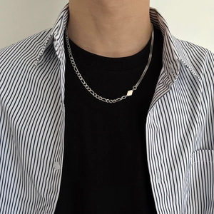 Detail of silver asymmetric mixed chain necklace with small geometric diamond pendant on neck