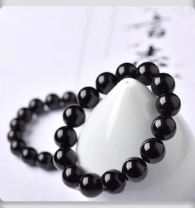 Vue rapprochée de deux bracelets en perles noires polies avec surface réfléchissante