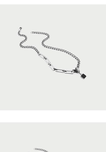 Dettaglio di una collana a catena mista stile industriale con ciondolo quadrato nero argento