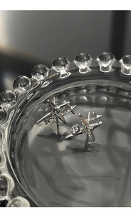 Detail shot of starburst stud earrings with zircons on a glass jewelry tray
