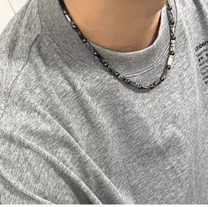 Close-up of black beaded necklace with zebra pattern texture on a model neck