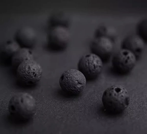 Macro view of porous black volcanic lava stone beads for jewelry making