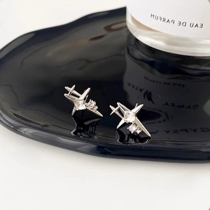 Macro view of silver starburst stud earrings with sparkling cubic zirconia on black ceramic