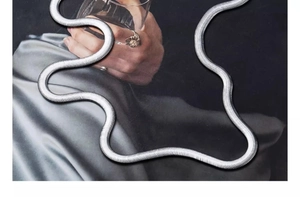 Dettaglio macro della collana a serpente argento con trama fitta e finitura in acciaio